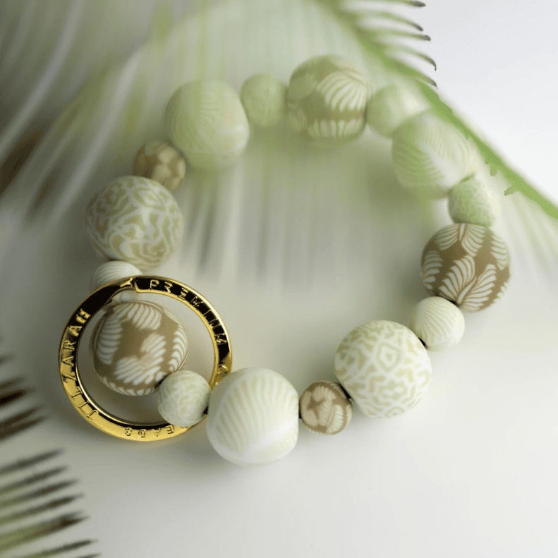 Ivory Palm Wrist Keychain with handcrafted beige clay beads, elastic cord, and gold key ring featuring JILZARAH logo.