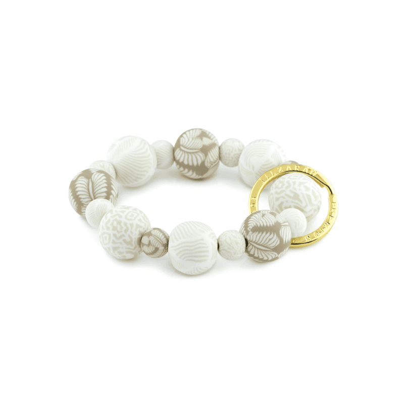 Ivory Palm Wrist Keychain with handcrafted beige clay beads, elastic cord, and gold key ring featuring JILZARAH logo.
