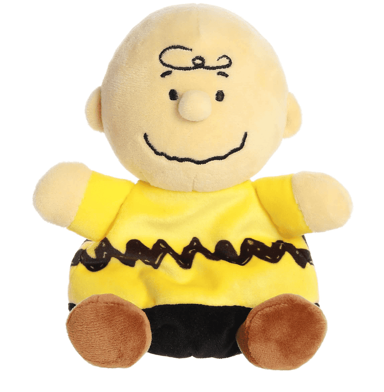 A small plush Charlie Brown doll with a round head and soft yellow shirt, part of the Palm Pals collection.