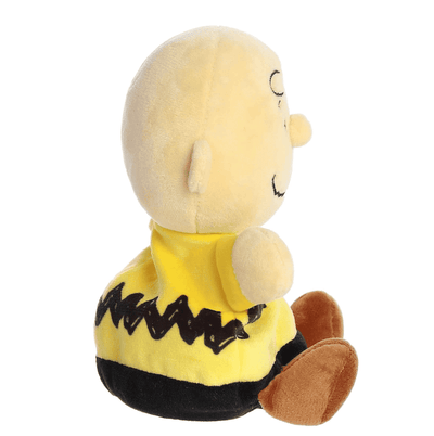A small plush Charlie Brown doll with a round head and soft yellow shirt, part of the Palm Pals collection.