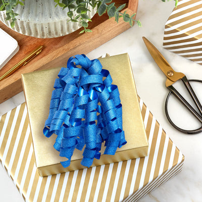 Hallmark blue curly ribbon gift bow with glitter finish, featuring self-adhesive backing and bold corkscrew curls for wrapped gift boxes.