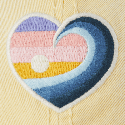 Yellow cotton chill cap with embroidered wave heart graphic and relaxed, sun-faded finish.

