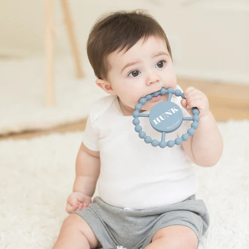Round silicone teether with the word "Hunk" printed on it, designed for babies with easy grip and textured surface.
