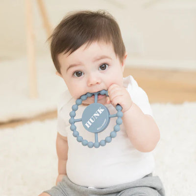 Round silicone teether with the word "Hunk" printed on it, designed for babies with easy grip and textured surface.