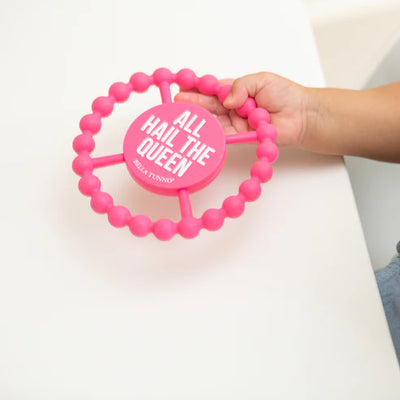 Circular silicone baby teether with "All Hail the Queen" phrase, textured edge, easy to grip and chew for teething relief.