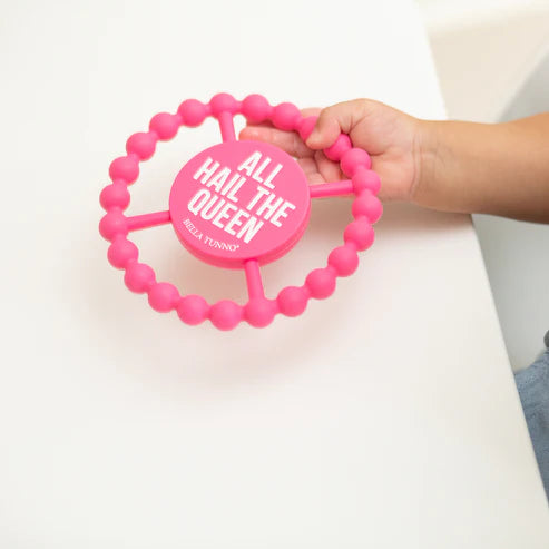 Circular silicone baby teether with "All Hail the Queen" phrase, textured edge, easy to grip and chew for teething relief.