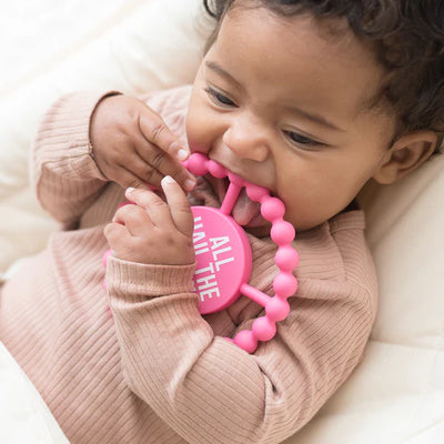 Circular silicone baby teether with "All Hail the Queen" phrase, textured edge, easy to grip and chew for teething relief.