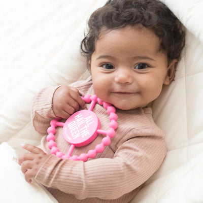 Circular silicone baby teether with "All Hail the Queen" phrase, textured edge, easy to grip and chew for teething relief.