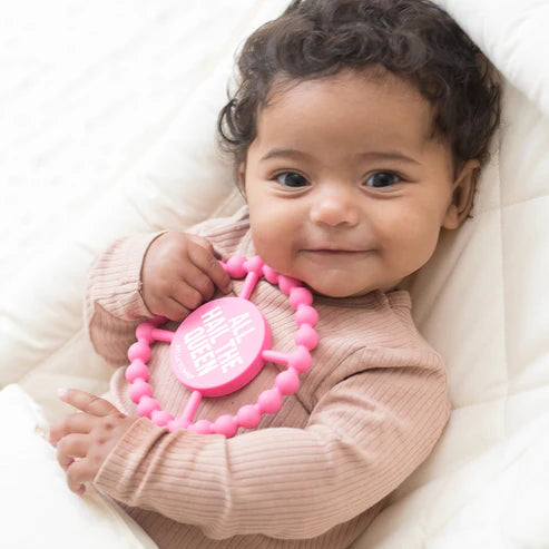 Circular silicone baby teether with "All Hail the Queen" phrase, textured edge, easy to grip and chew for teething relief.