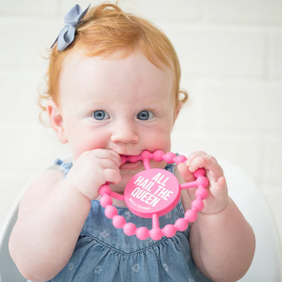 Circular silicone baby teether with "All Hail the Queen" phrase, textured edge, easy to grip and chew for teething relief.