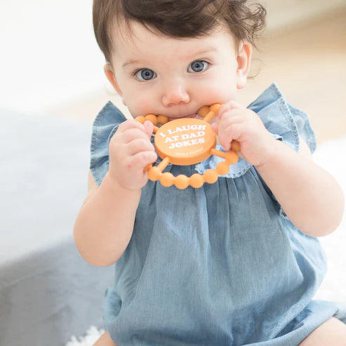 Round silicone teether with "I Laugh at Dad Jokes" text, beaded edge for teething relief, perfect for baby grip and chewing.