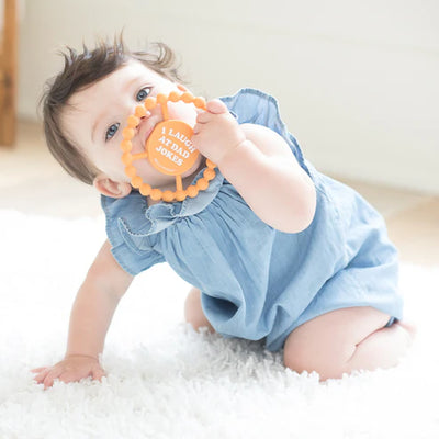 Round silicone teether with "I Laugh at Dad Jokes" text, beaded edge for teething relief, perfect for baby grip and chewing.