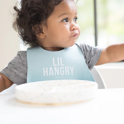 Colorful silicone baby bib with 'Lil Hangry' phrase and large food-catching pocket.