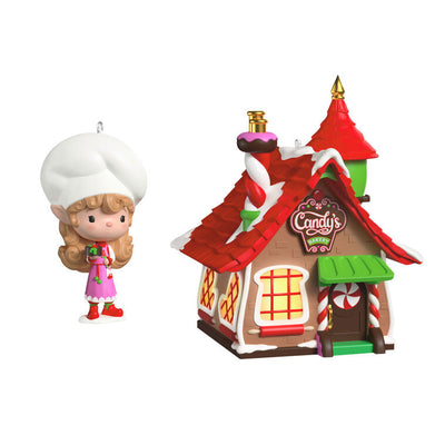 Two-piece ornament set with a festive bakery shaped like a gingerbread house and a smiling elf named Candy holding chocolate cake.