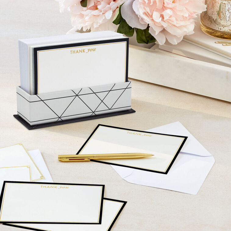 Blank flat note cards with gold lettering and black borders, includes envelopes and white caddy with black geometric lines.