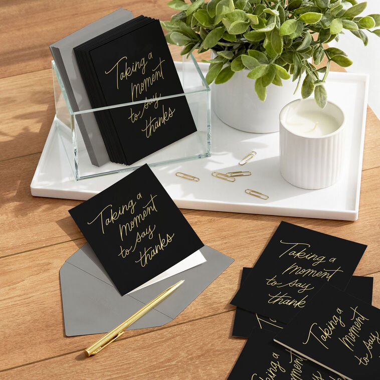 Black thank-you cards with elegant gold foil script reading “Taking a moment to say thanks.”
