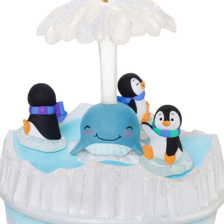 Christmas ornament with three playful penguins spinning on ice pieces around whale, lights and music, battery operated

