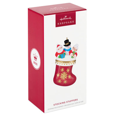Hallmark Keepsake Stocking Stuffers ornament—red and white stocking with gold snowflakes, Santa, Mrs. Claus, and snowman in vintage style
