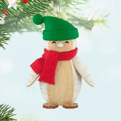 Penguin Christmas ornament styled like birch wood, wearing red scarf and green stocking hat
