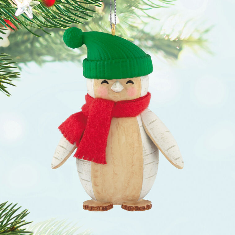Penguin Christmas ornament styled like birch wood, wearing red scarf and green stocking hat