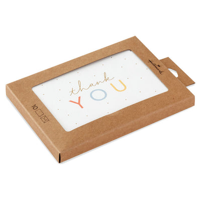 White thank-you cards with pastel-colored lettering and scattered gold foil dots, packaged in a kraft box with matching envelopes.
