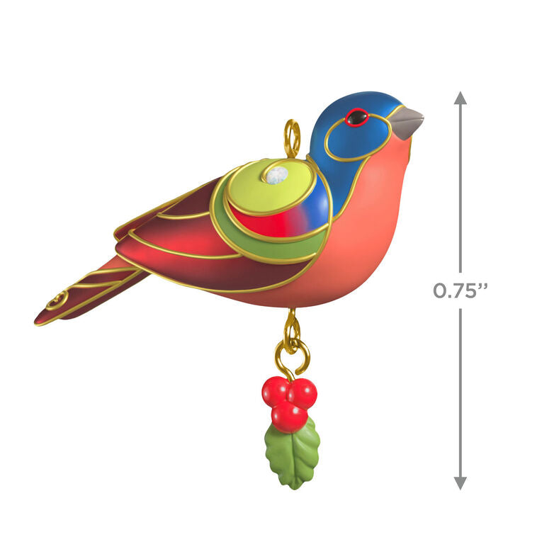 Painted Bunting miniature Christmas tree ornament with colorful feathers, metallic gold trim, and dangling holly berry charm