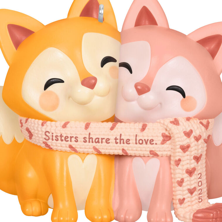 2025 Christmas ornament with two foxes snuggled in a heart-patterned scarf, celebrating sisterly love

