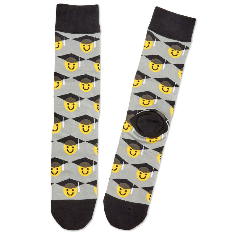 Class of 2025 black-and-white trinket tray with matching socks featuring smiley faces in graduation caps.

