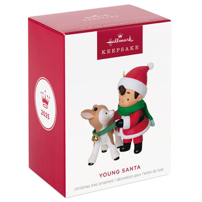 Hallmark Keepsake Young Santa ornament—Santa as a boy in red hat and coat, green scarf, placing green collar with gold bell on young reindeer
