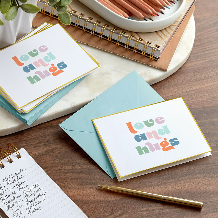 Pastel mod-style “Love and Hugs” blank note cards with gold foil frame on ivory paper, in kraft box.
