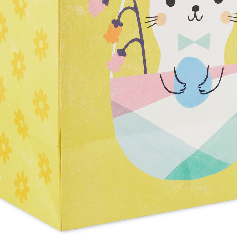Hallmark Easter gift bag with white bunny in pastel basket on yellow background and floral accents.