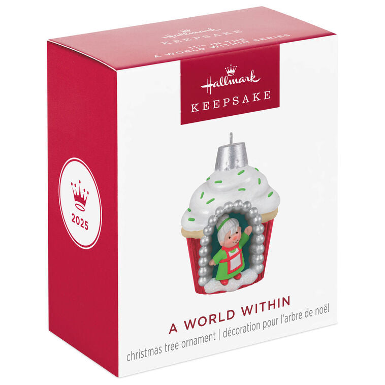 Mini cupcake-shaped ornament with Mrs. Claus waving from a silver-dotted doorway, topped with white icing and green sprinkles.