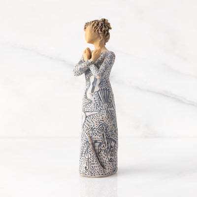 Willow Tree Music Speaks figurine with lighter skin featuring a dress carved with musical symbols and dancing figures.