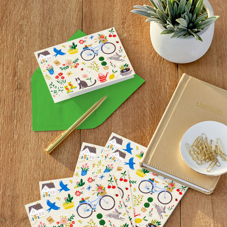 Garden-themed blank note cards with flowers, bike, and house illustrations on white background, 10-pack with envelopes and matte finish.
