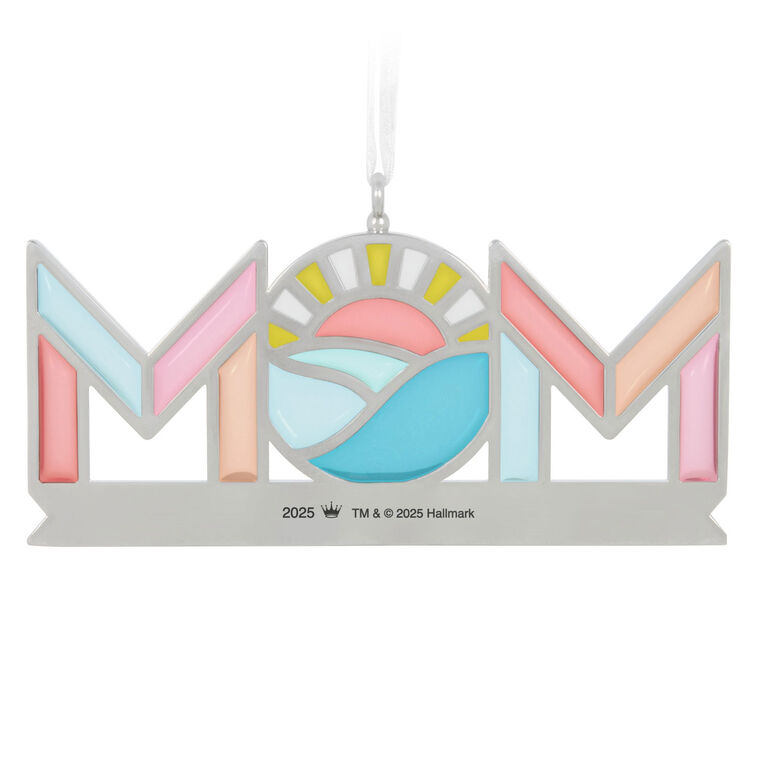 Stained-glass style metal ornament spelling “Mom” with sun and waves in the O, and banner reading “Your love shines through.”