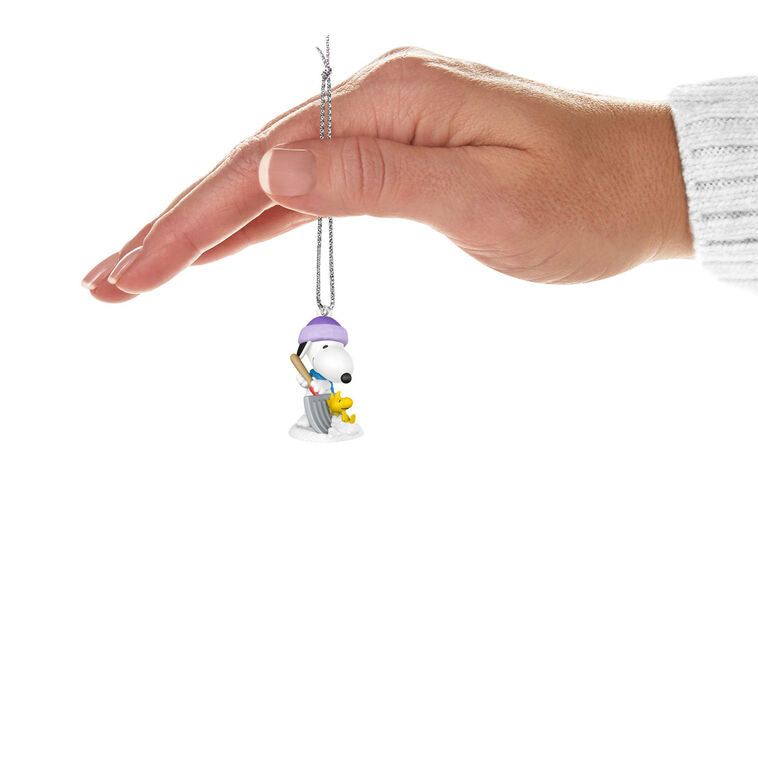 Mini Snoopy ornament in purple hat and scarf shoveling snow, Woodstock riding on shovel, Hallmark Peanuts Christmas collectible