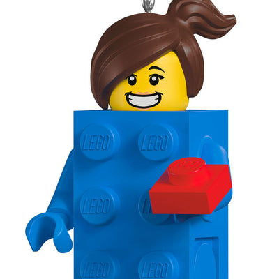 LEGO minifigure ornament with blue brick body, red piece in hand, and smiling brunette girl face.