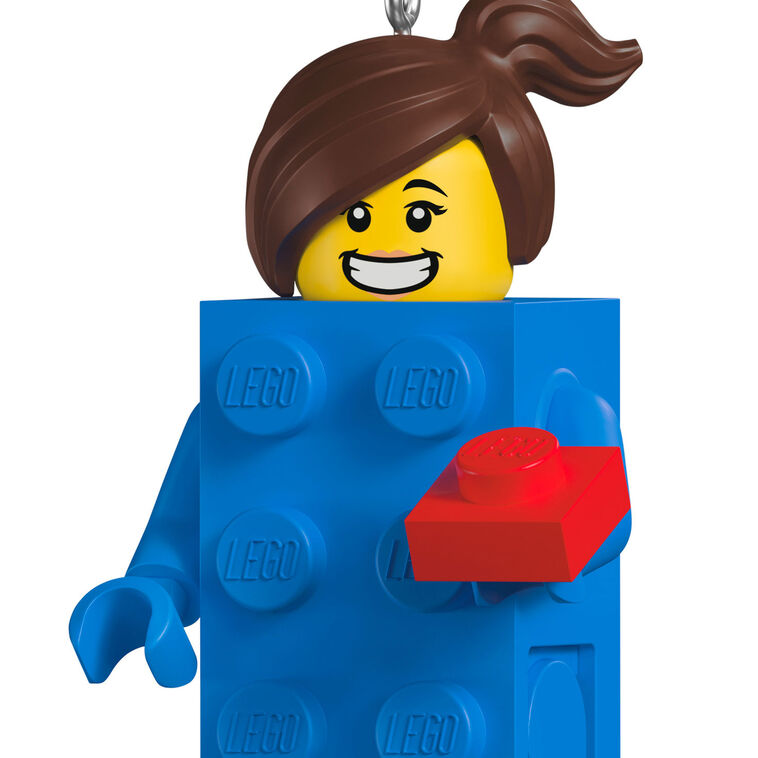 LEGO minifigure ornament with blue brick body, red piece in hand, and smiling brunette girl face.