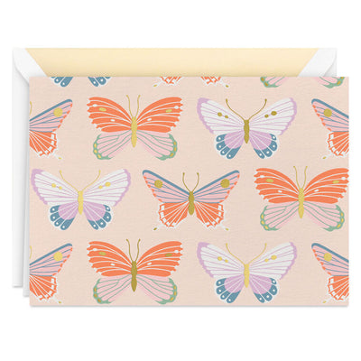 Blank note cards with colorful butterfly illustrations and gold foil accents on a soft peach background.