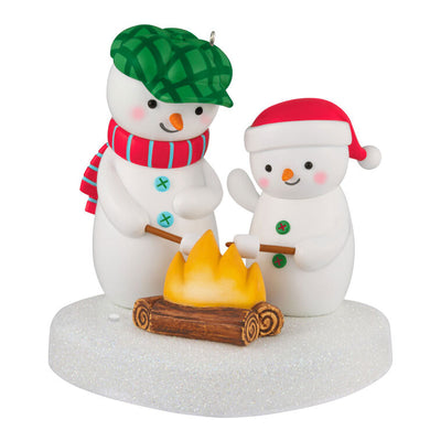Two snowmen in red and green hats roasting marshmallows over a fire, sparkly base, musical Christmas ornament, battery opera
