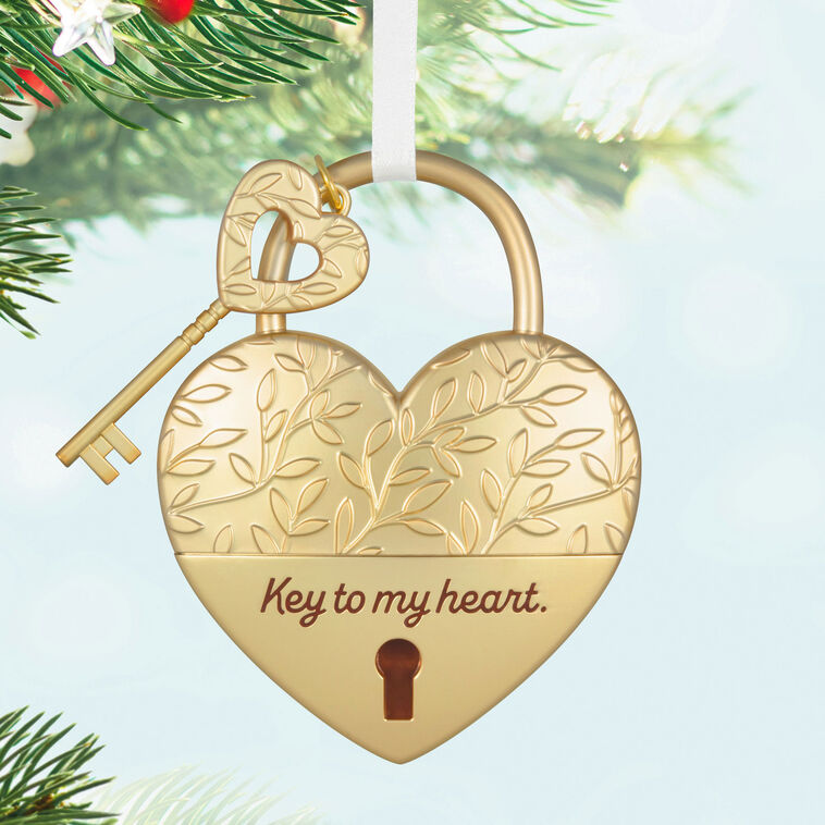 Gold metal heart ornament with leaf-vine design and key, engraved with “Key to my heart” — a romantic gift for newlyweds or partners.