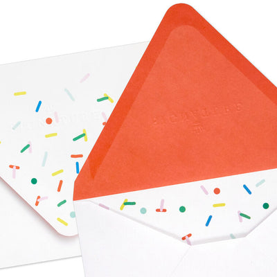 White envelopes with colorful confetti sprinkle design and orange flap interior, perfect for festive notes.
