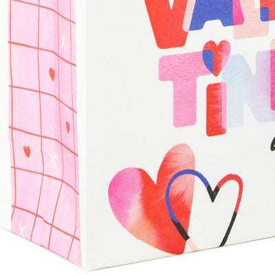 Mini Valentine's Day gift bag with colorful heart and script design on white background.