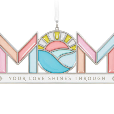 Stained-glass style metal ornament spelling “Mom” with sun and waves in the O, and banner reading “Your love shines through.”