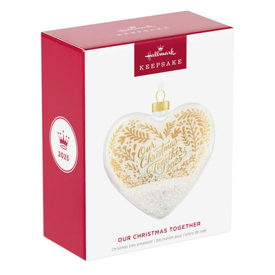 Glass heart Christmas ornament with snow, gold greenery accents, and “Our Christmas Together 2025” message.

