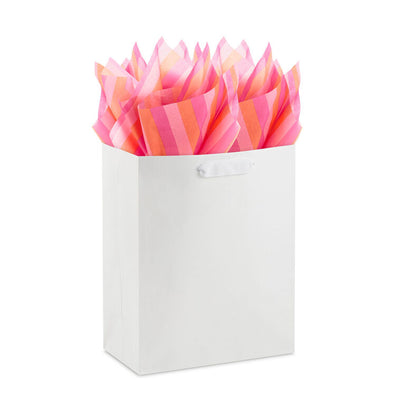 Hallmark tissue paper in horizontal magenta, orange, and pink stripes, styled in flat lay and fluffed in a gift bag for festive presentation
