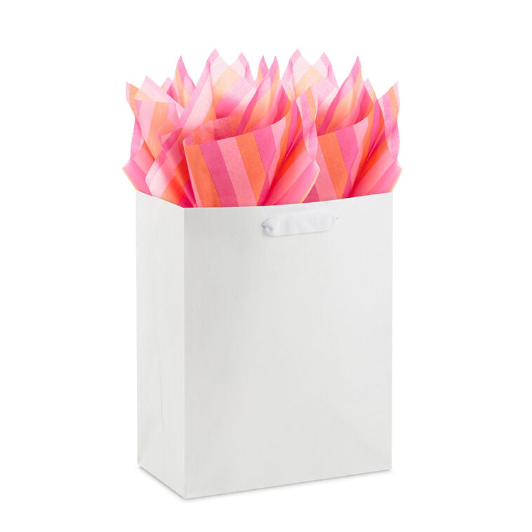 Hallmark tissue paper in horizontal magenta, orange, and pink stripes, styled in flat lay and fluffed in a gift bag for festive presentation