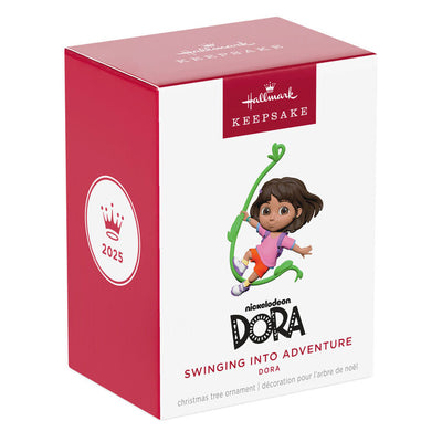 Dora the Explorer ornament swinging on jungle vine, pink shirt, orange shorts, purple backpack, Hallmark Keepsake holiday decor.