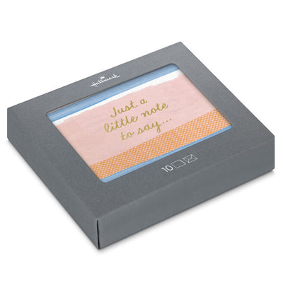 Note cards with pink, blue, and orange brushstroke stripes and gold script reading “Just a little note to say…”, boxed with envelopes.
