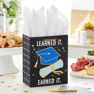 Medium black graduation gift bag with "Learned It. Earned It." and blue mortarboard and diploma, Hallmark, gold foil accents, 9.6 inch size
